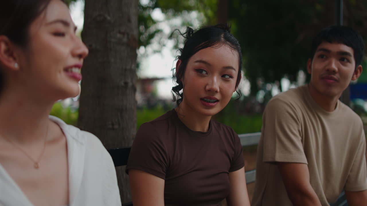 Three people sitting outdoors and talking