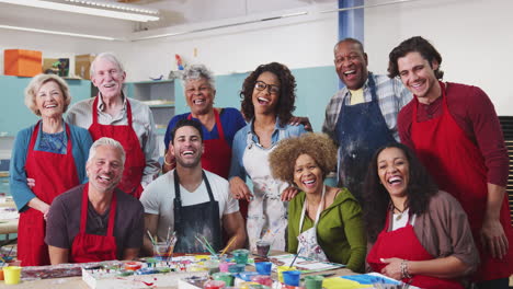 portrait of mature and senior adults attending art class in community centre with teacher