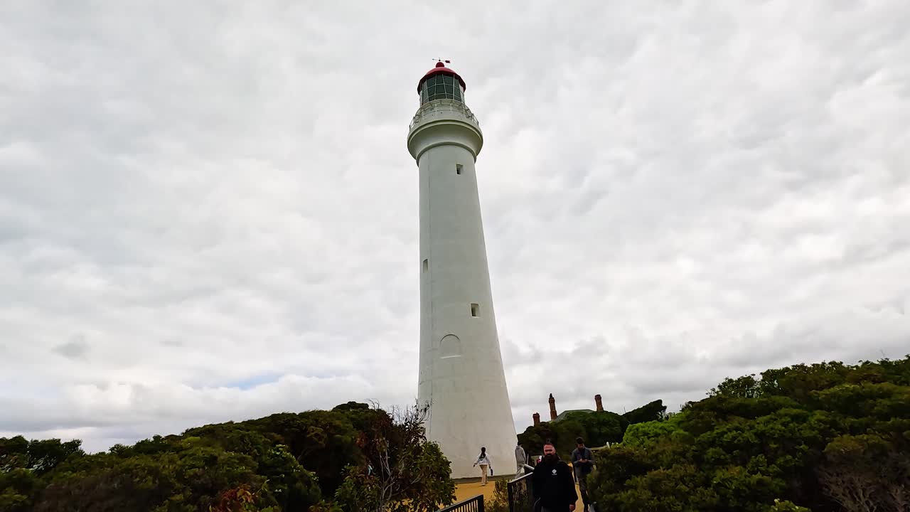 Panoramic views of a lighthouse and lush coastline under cloudy skies at Aireys Inlet, Victoria, Australia