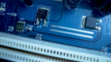 top view of computer motherboard chip in blue light. detail of electronic components on pc motherboard. motherboard computer electrical circuit with cip, slots, microchip and microprocessors. close up