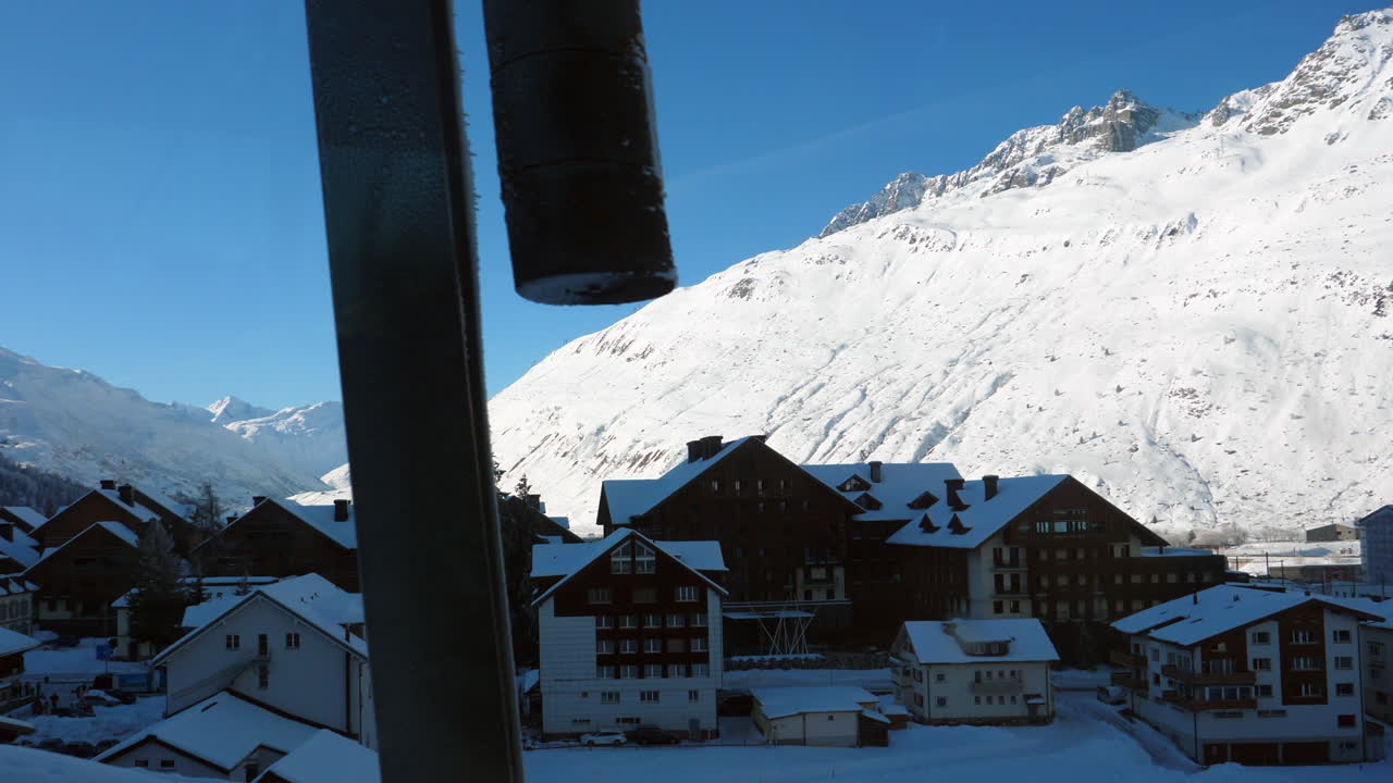vista de casas y hoteles suizos desde a bordo del tren expreso glaciar con reflejo de ventana