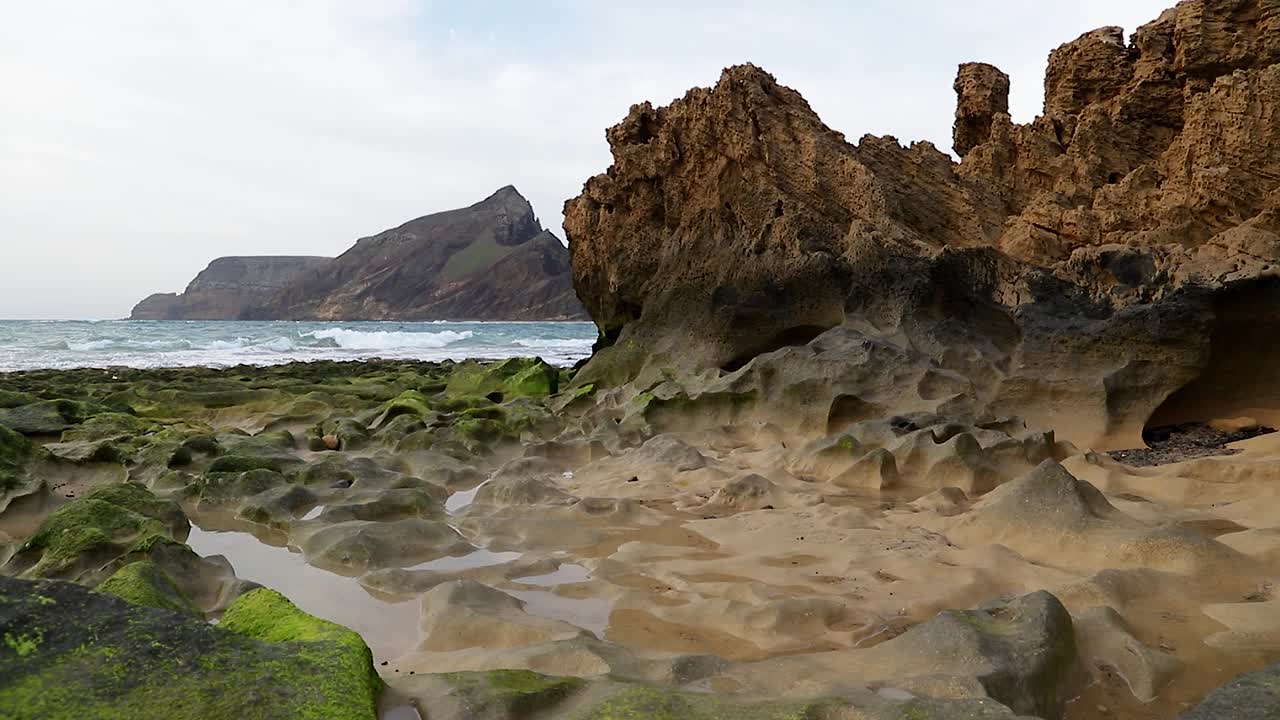 impresionante paisaje marino cinematográfico con rocas de erosión cubiertas de algas verdes, charcos de agua de mar y olas