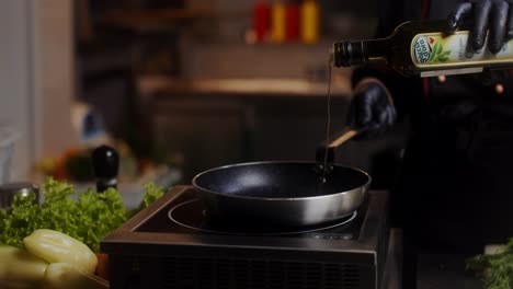 chef pouring olive oil into a pan