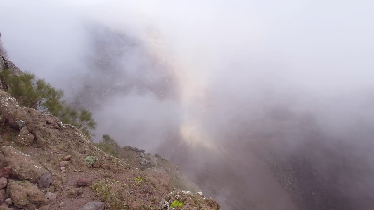 una vista de nubes de niebla que se derraman en el cráter del monte vesubio en nápoles, italia - fotografía panorámica