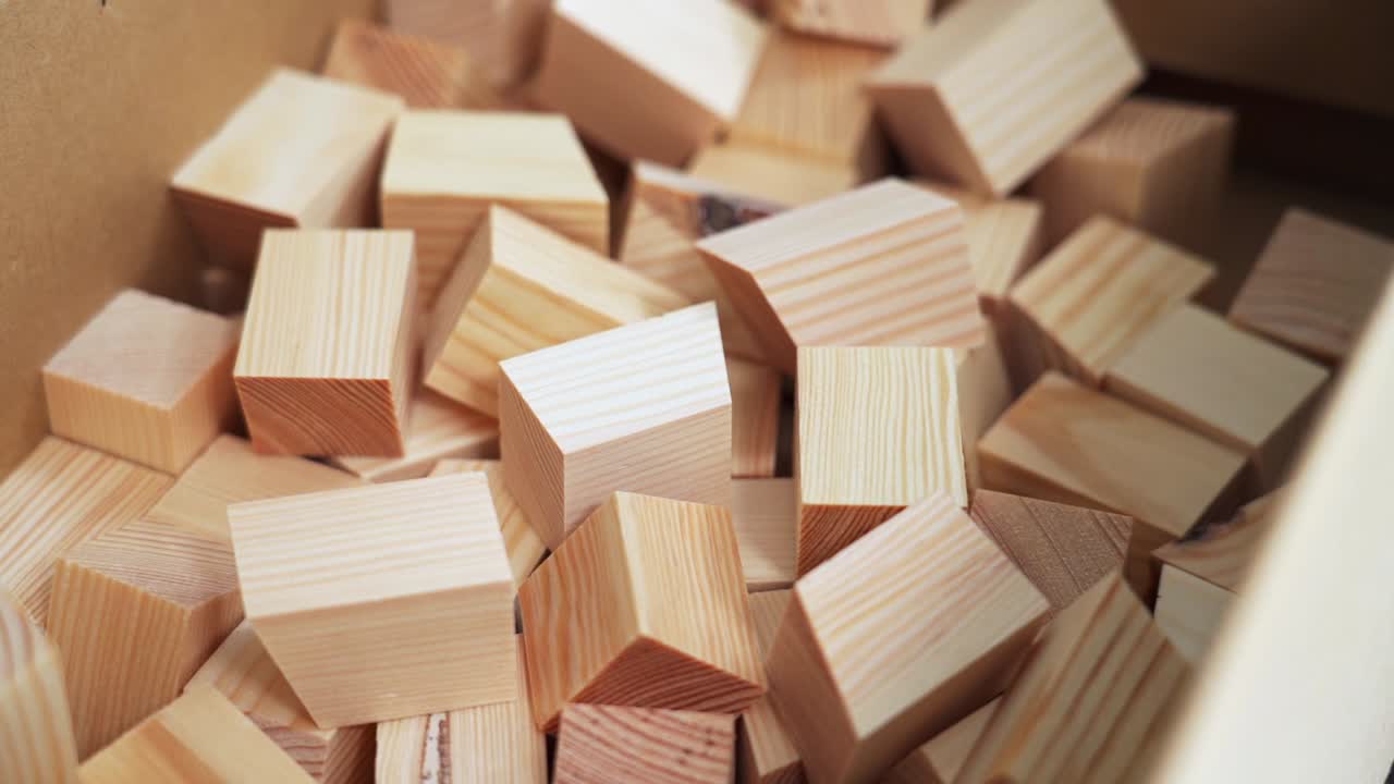 Hand selecting small wooden blocks from a box