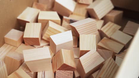 Hand selecting small wooden blocks from a box