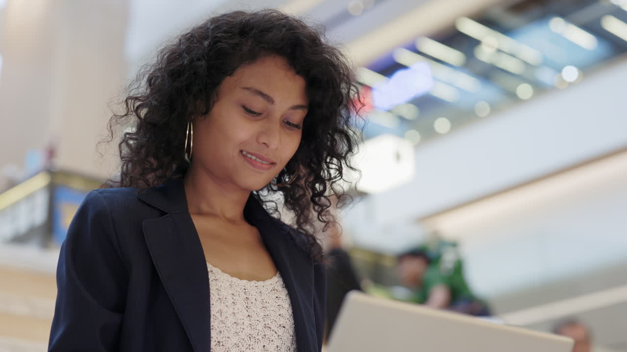 Woman Working on Laptop in a Shopping Mall