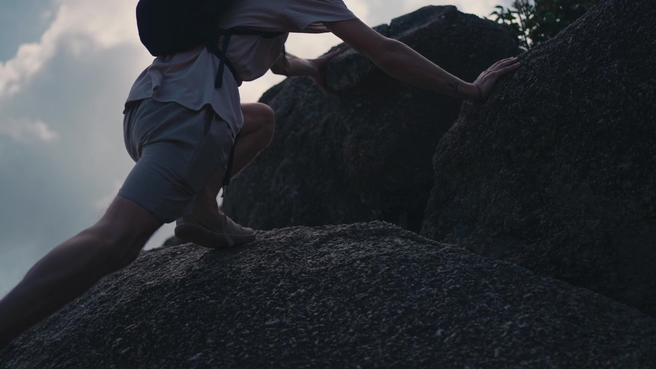 Man hiking up steep rocks in Koh Phangan Thailand