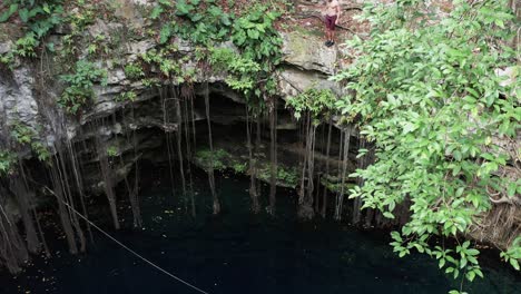 cliff jumping into a cenote hole in the yucatán region of mexico