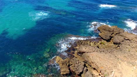 aerial-shot-by-drone-of-the-waves-breaking-on-the-rocks