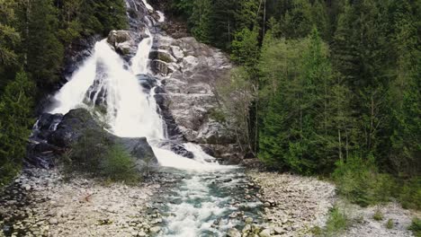 Low-drone-shot-of-Silver-Falls-waterfall-in-forest-in-Deep-Cove,-Vancouver,-Canada