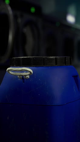 blue container in a laundromat with washing machines in the background
