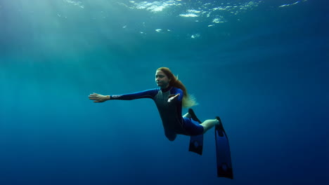 underwater freediving with a woman in blue ocean