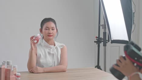 behind the scenes on photo shoot: beautiful asian model poses for a photographer, she takes photos with professional camera
