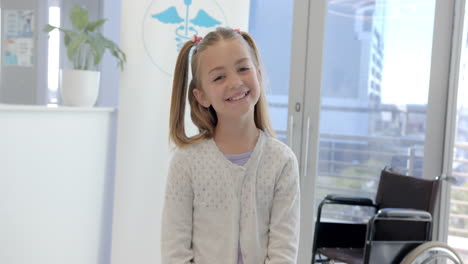 Portrait-of-happy-caucasian-girl-patient-with-long-hair-smiling-in-hospital-reception,-slow-motion