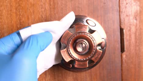 limpieza de una manija de la puerta con guantes
