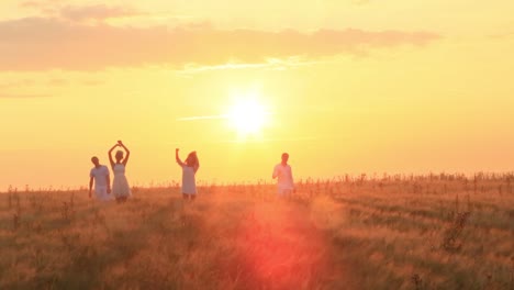 friends enjoying a sunset in a wheat field