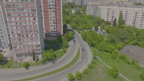 Aerial-shot-of-cars-driving-past-large-apartment-complexes-in-Tbilisi,-Georgia