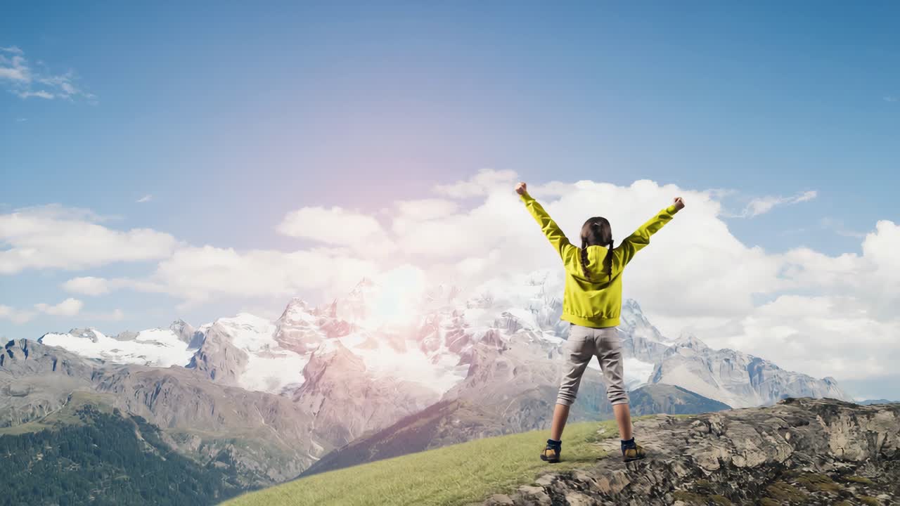 Woman standing on mountain top with arms raised in success