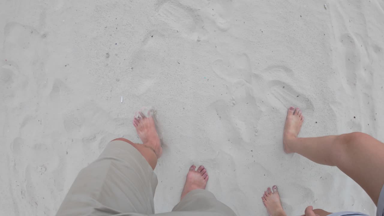 Engaging point-of-view footage featuring a person's legs walking on sandy terrain