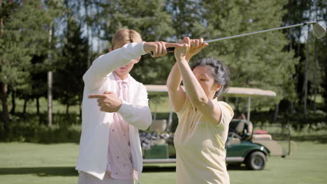 Golflehrer-Hilft-Asiatischen-Reifen-Frauen-Bei-Den-Golfhaltungen