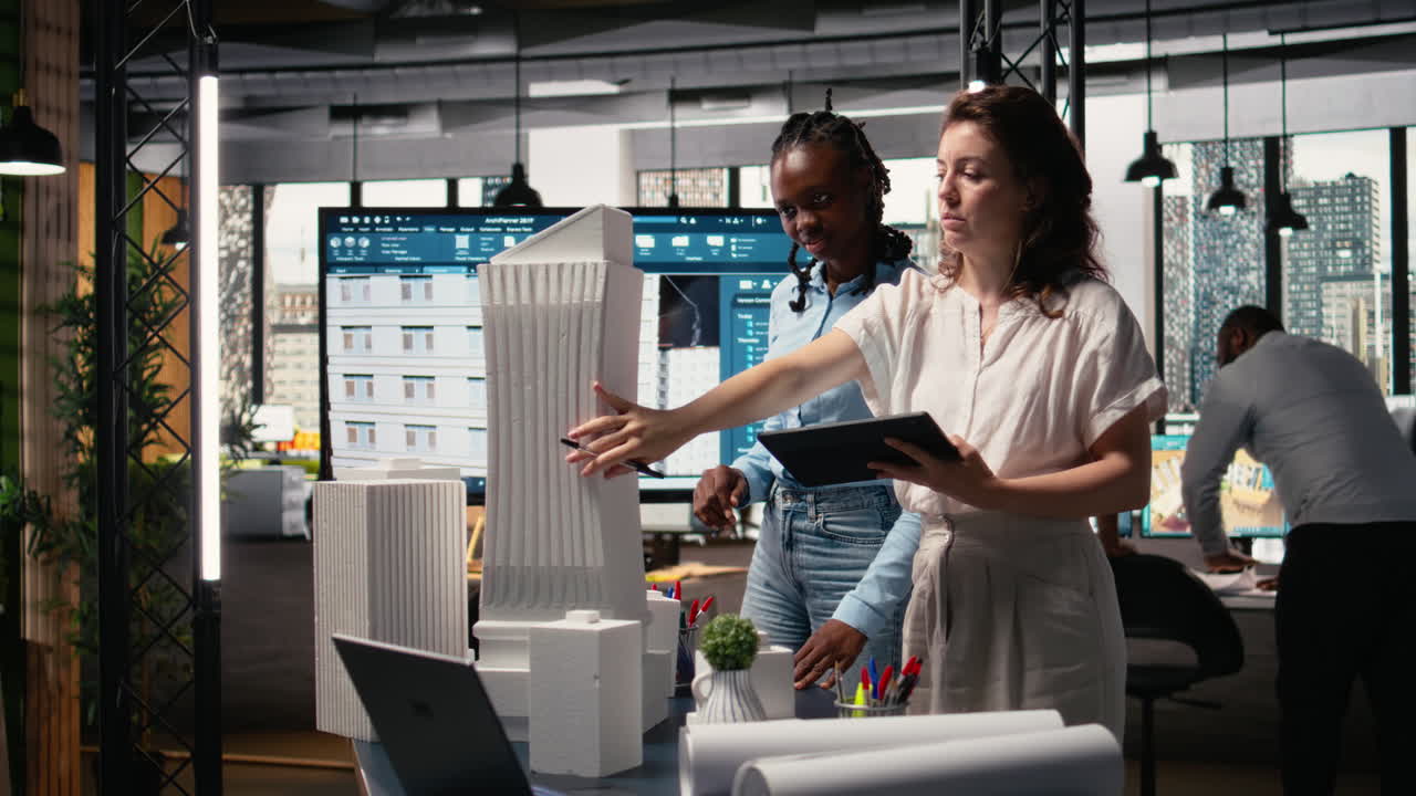 Diverse female contractors sharing structural layout ideas for residential area