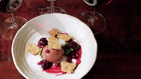 Postre-De-Alta-Cocina-De-Crémeux-De-Chocolate-Con-Leche-Con-Cerezas-De-Anís-Estrellado,-Mantecada-De-Aceitunas-Negras,-Granada,-Mejorana-Y-Espuma-De-Regaliz