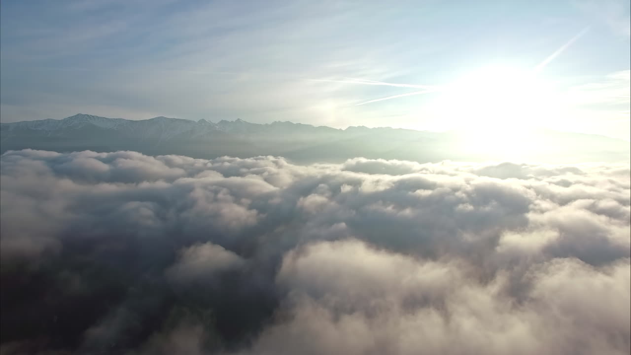Ascendendo sopra il paesaggio di nuvole per vedere l'alba e la catena montuosa.