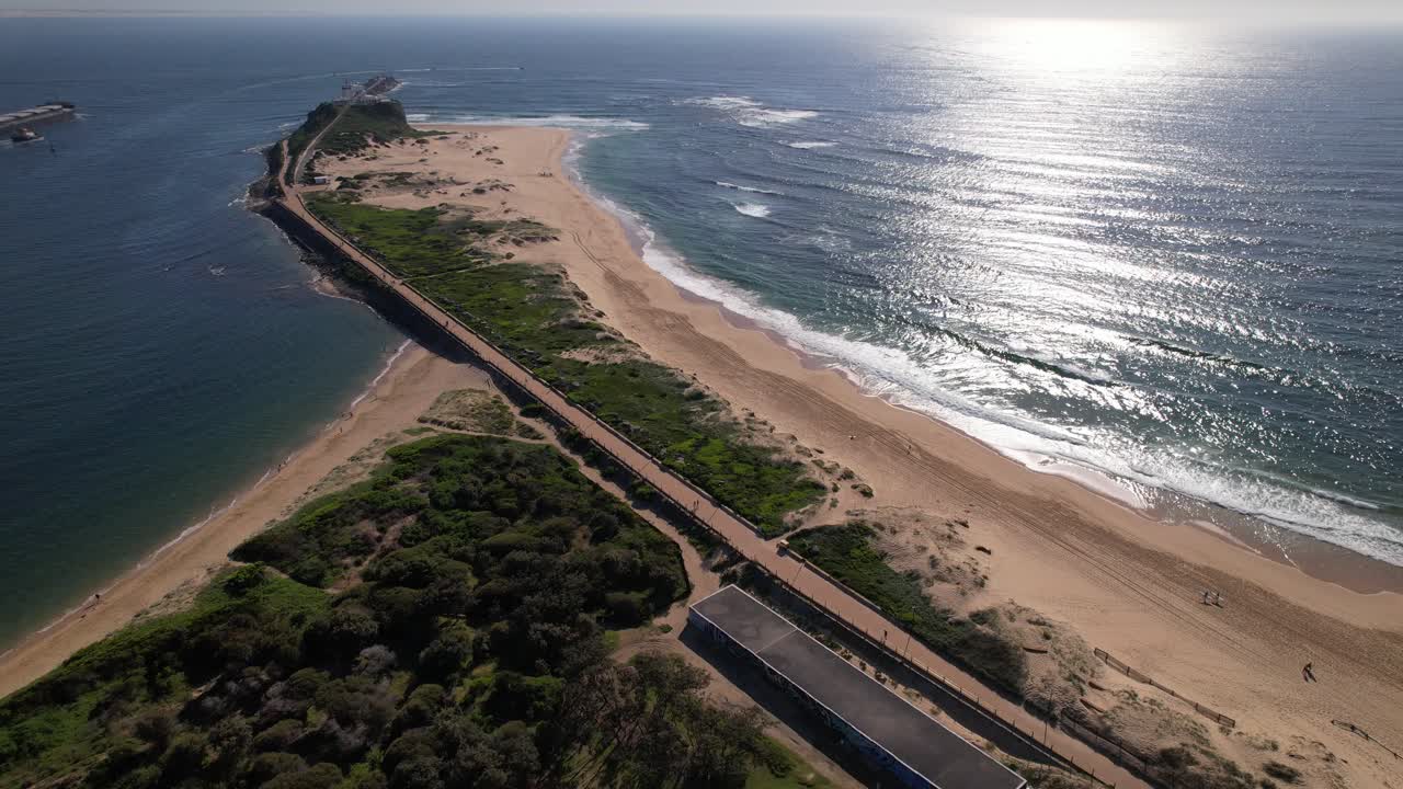 Horseshoe Beach And Nobbys Beach At Entrance Of Hunter River In Newcastle, NSW, Australia. aerial pullback shot