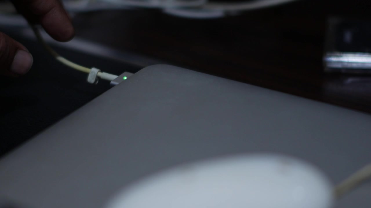 Close Up of Hand Plugging Charging Cable into Laptop