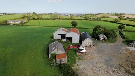 tilt down aerial view of barns and farmhouse in irish countryside