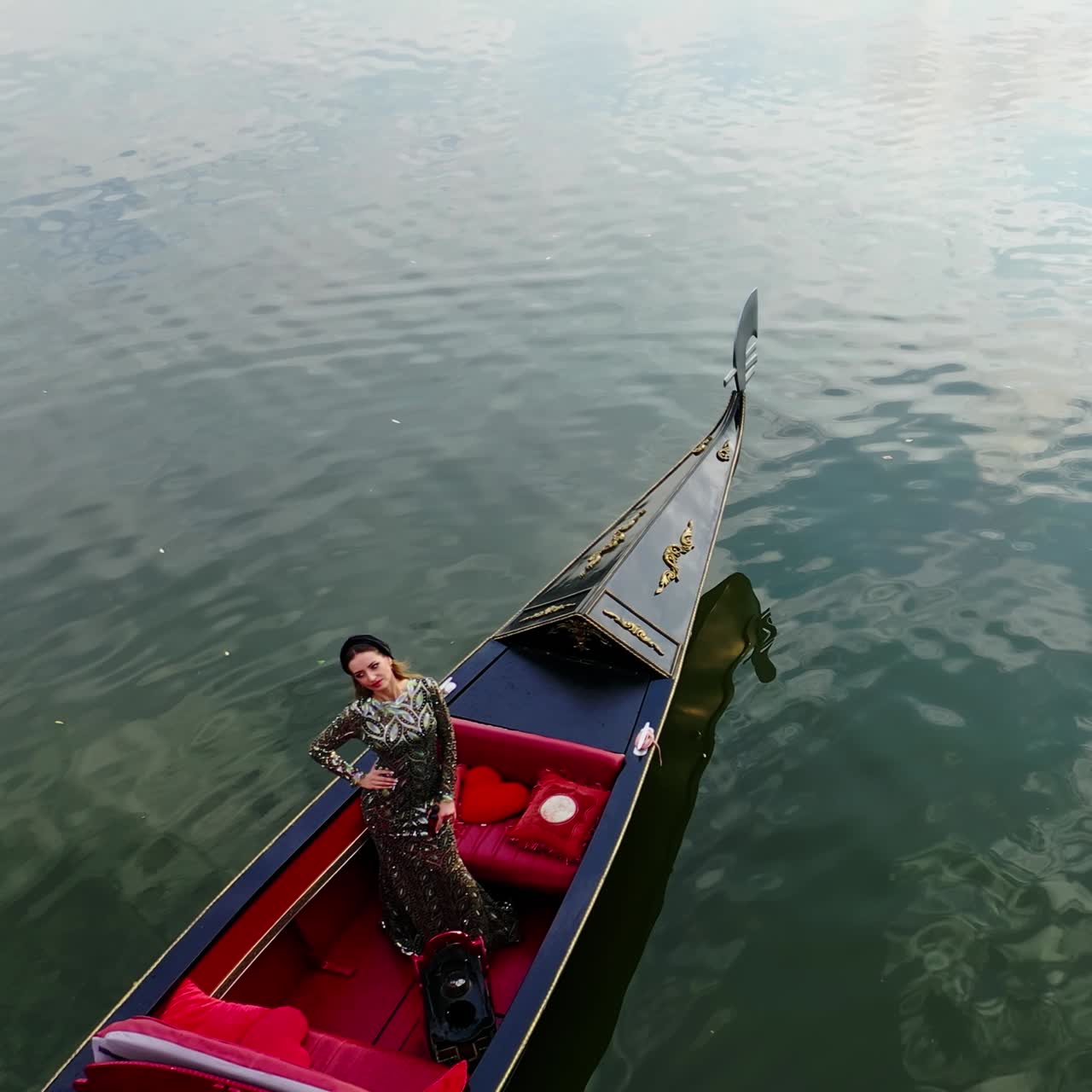 Gondola on water. Beautiful woman in long dress riding in gondola and admiring the nature view. Gondolier managing boat on the river. Aerial View.