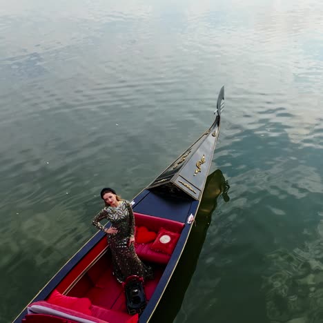 gondola on water. beautiful woman in long dress riding in gondola and admiring the nature view. gondolier managing boat on the river. aerial view.