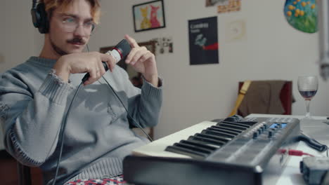 thoughtful musician in headphones sitting at home recording studio