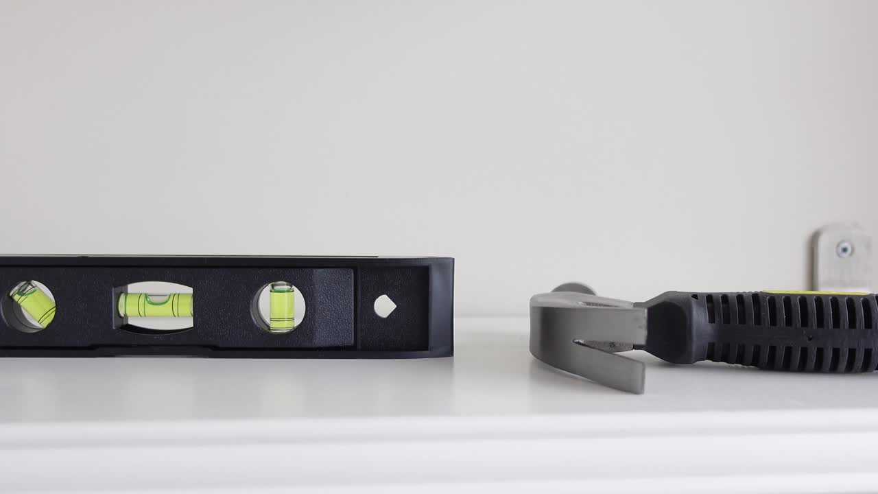 Level and tools on a white surface