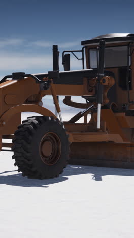 orange grader on snow