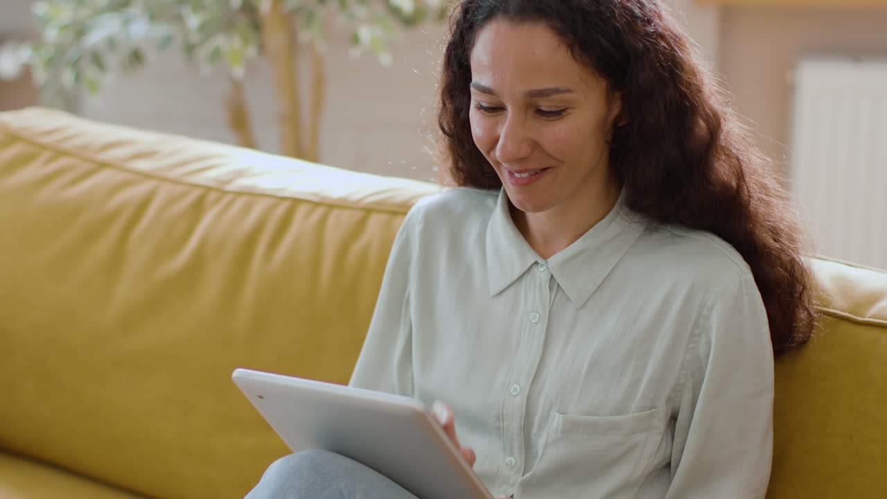 mujer usando una tableta en un sofá
