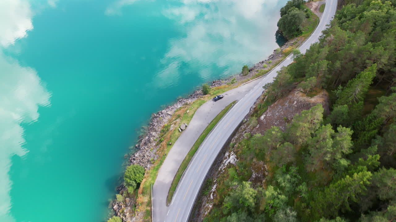 un camino sinuoso y increíbles reflejos del cielo en el lago oppstrynsvatnet