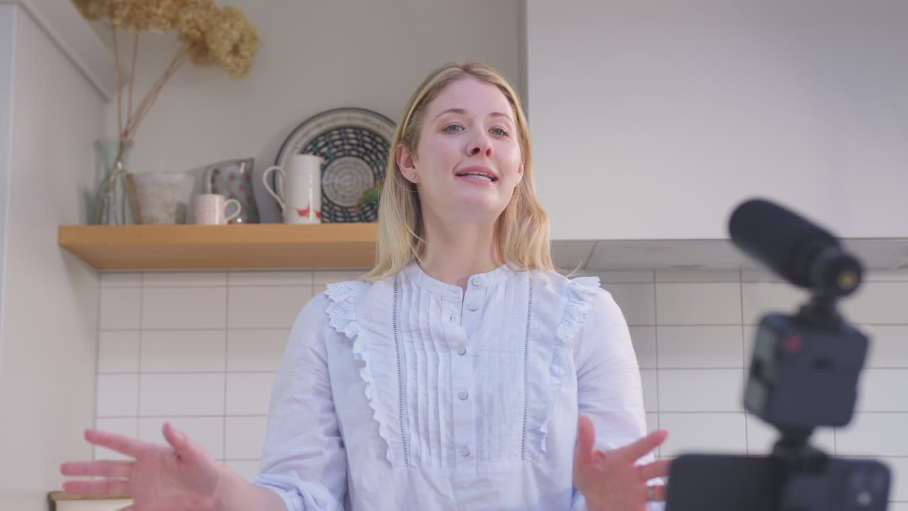 mujer vlogging haciendo video de redes sociales sobre la comida en casa en la cocina en el teléfono móvil - filmado en cámara lenta