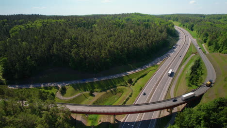 4K-Drohnenaufnahmen-Von-Autobahnüberführungen-Mit-Lastwagen-In-Waldumgebung