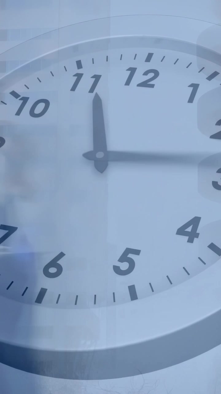 Video vertical: Reloj analógico de oficina avanzando las manecillas con motor, siguiendo los minutos con sombra.