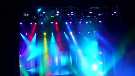 many spotlights that illuminate stage at concert.