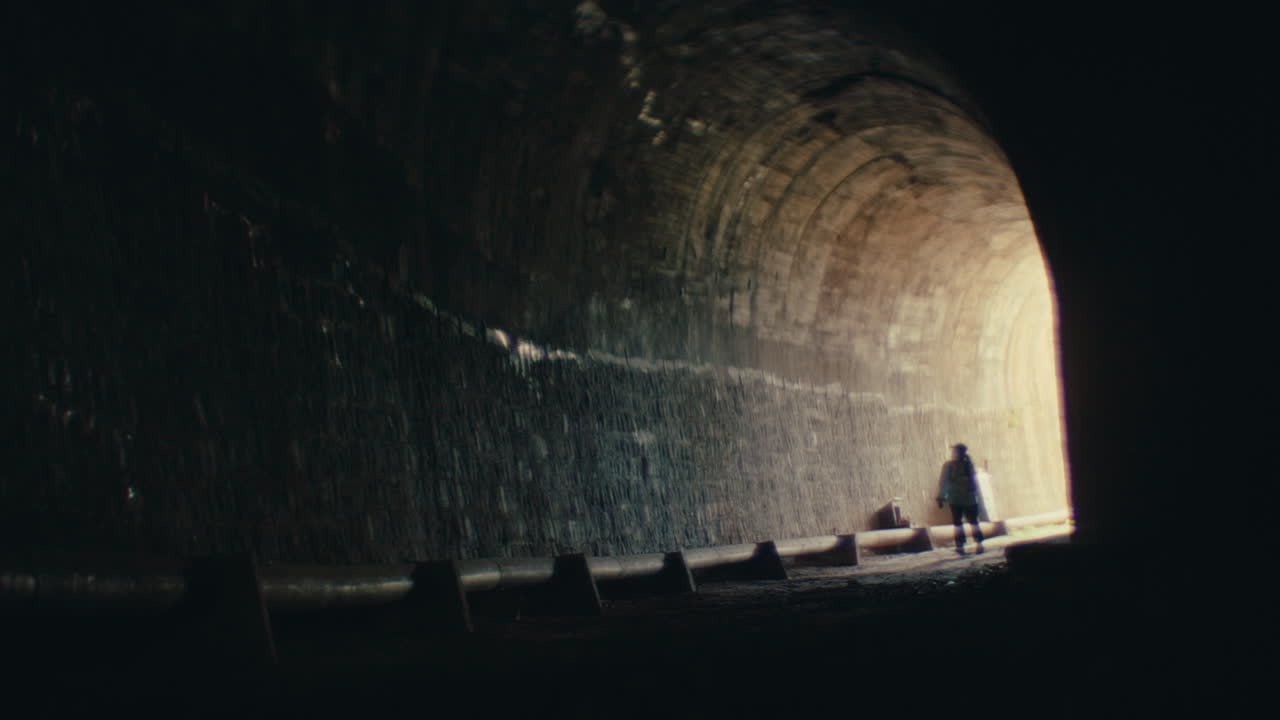 persona caminando por un túnel oscuro