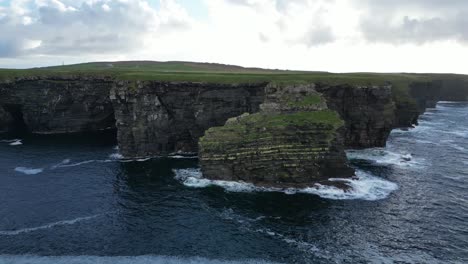 Majestuosos-Acantilados-De-Kilkee-Que-Se-Encuentran-Con-El-Océano-Atlántico-Con-Olas-Rompiendo,-Vista-Aérea