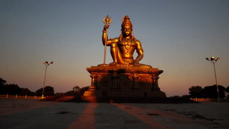 golden statue of hanuman at sunrise