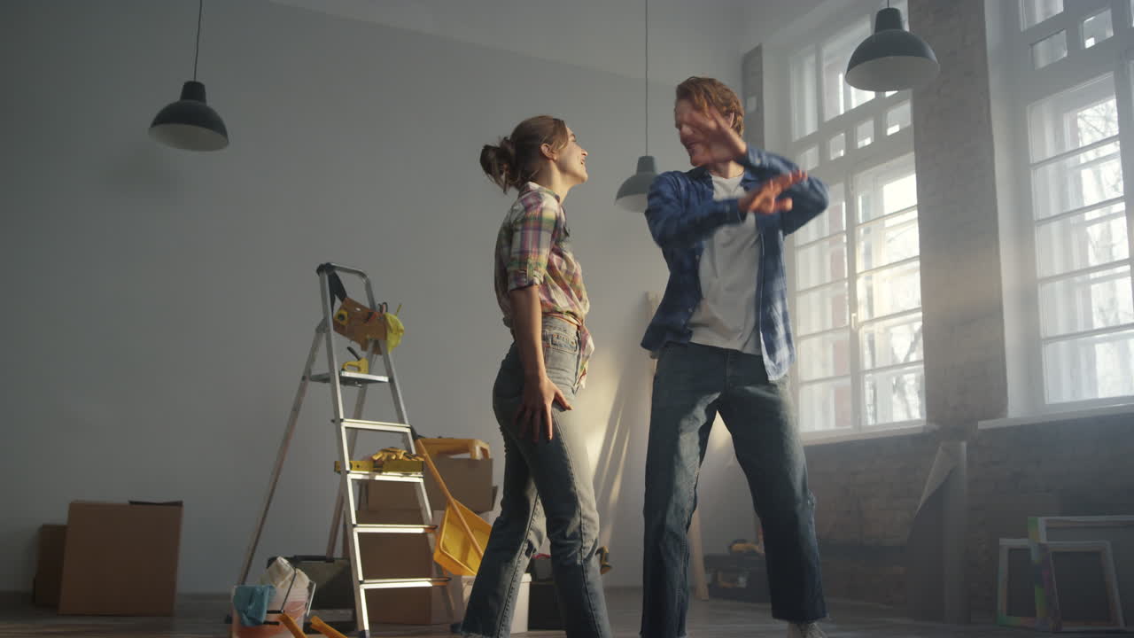 счастливая семья празднует в квартире. мужчина кружит женщину в руках в помещении.