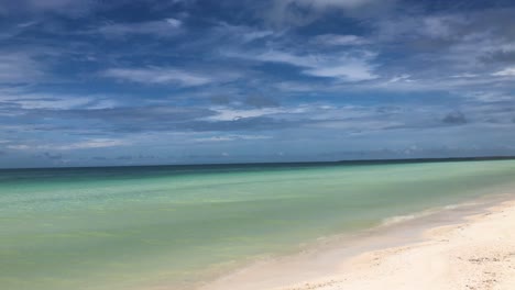 Panorámica-De-La-Cámara-A-Lo-Largo-De-La-Desierta-Playa-De-Arena-Blanca-Del-Caribe