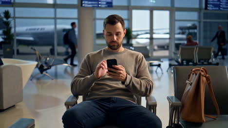 man using smartphone at airport