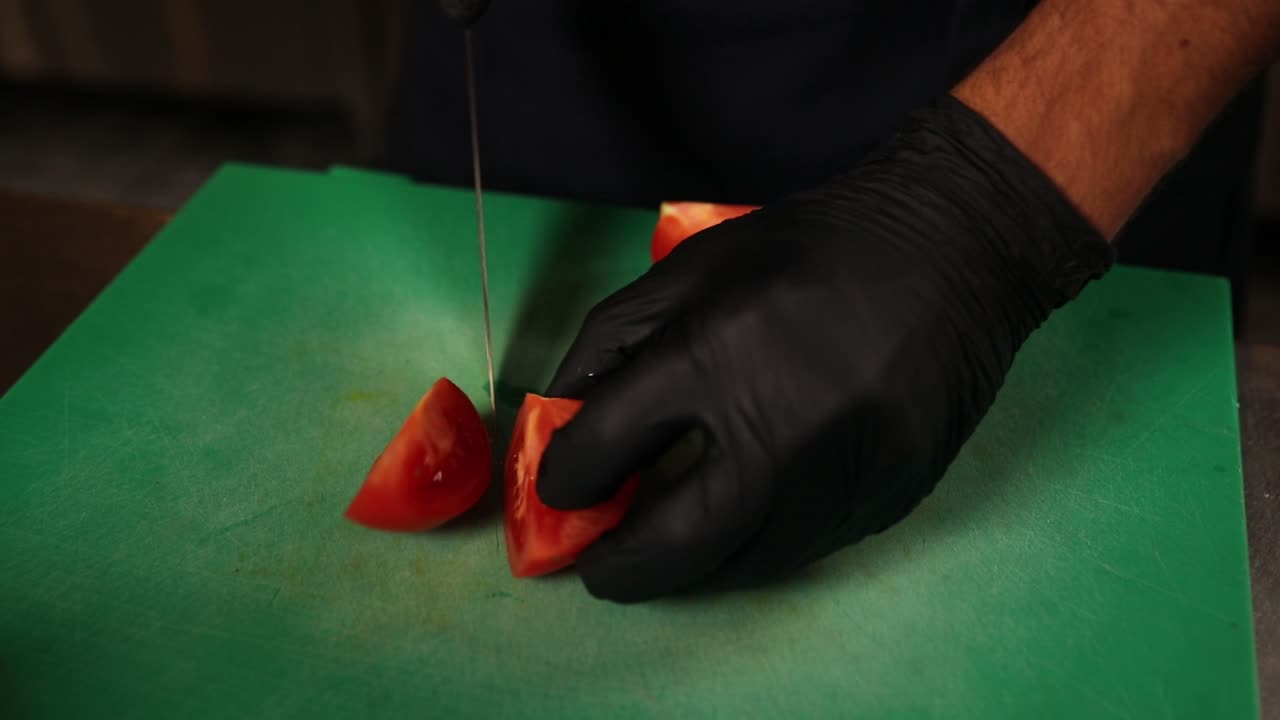 셰프가 토마토를 잘라내고 있습니다.