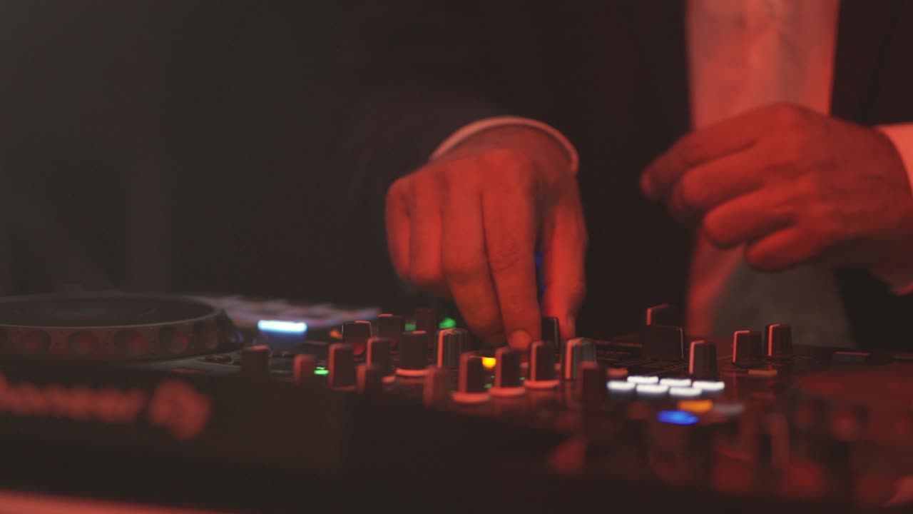 manos de dj creando y regulando la música en la consola de mezclador en la fiesta de bodas